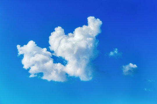 tranquil fluffy white cloud at a blue summer sky background.