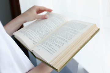 Fototapeta premium Woman reading book near window
