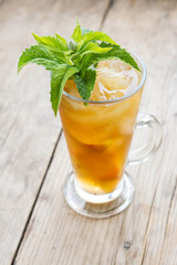 Glass of sweet peach iced tea on the wooden table