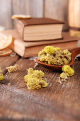 Old books with dry flowers on table close up