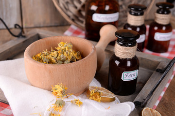 Dried herbs and bottles with tinctures on table close up