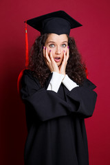 Studio portrait picture from a young graduation woman on red background