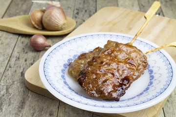 pork stick grilled in a plate on wooden