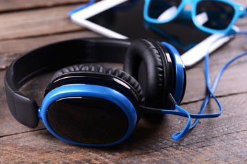 Headphones with tablet on wooden background