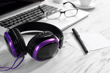 Headphones with laptop on table close up