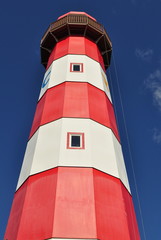 red and white lighthouse against blue sky