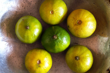 Fototapeta na wymiar Fresh Green Lemons put in Silver Plate.