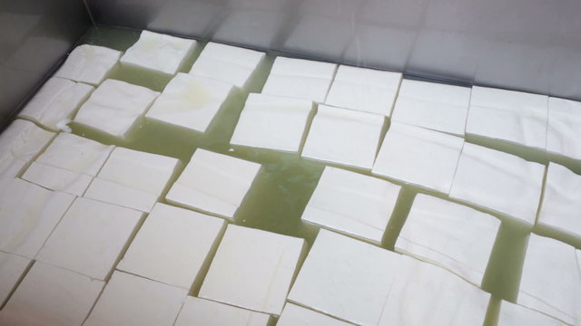 The process of producing tasty traditional white Bulgarian feta cheese at its final stage before packeting. Feta cheese cubes.