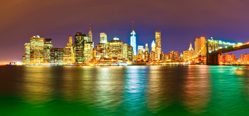 Naklejka premium Panorama of Manhattan skyline and Brooklyn Bridge at night.