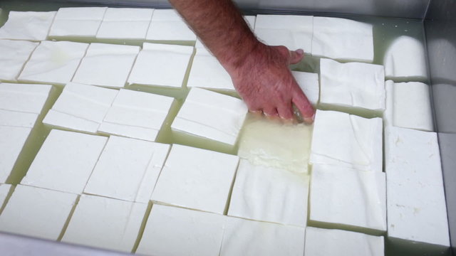 The process of producing tasty traditional white Bulgarian feta cheese at its final stage before packeting. Feta cheese cubes.