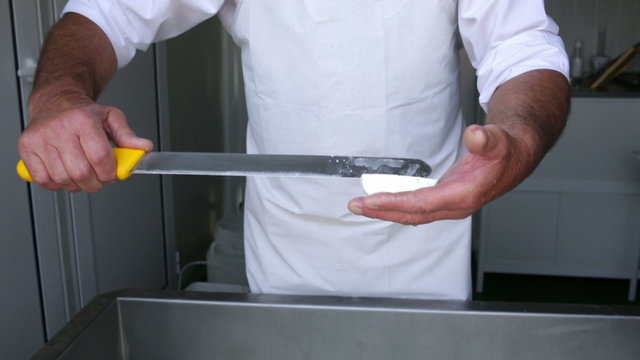 The process of producing tasty traditional white Bulgarian feta cheese at its final stage before packeting. Cutting with a knife.
