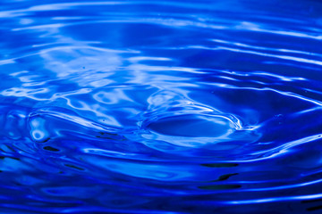 Blue water drop falling down background.