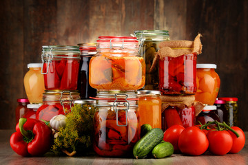 Fototapeta na wymiar Jars with pickled vegetables and fruity compotes