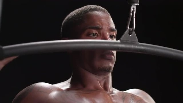 Muscular black man performing a lat pulldown