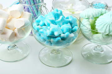Fototapeta na wymiar Sweet candies in glassware on table, closeup