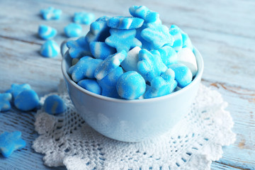 Cup of sweet candies on wooden table, closeup