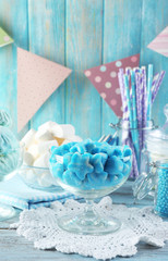 Sweet candies in glassware on wooden background