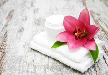 Fototapeta na wymiar cosmetic cream and pink lily flower