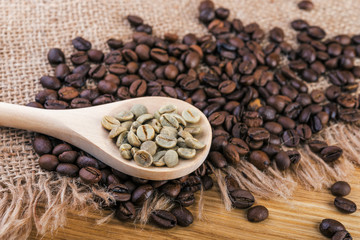  Coffee beans in spoon on burlap and wooden background.