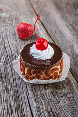 Tasty chocolate cake with berries on wooden table