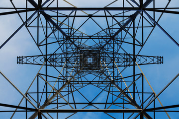 A view on electricity pylons from below against the sky