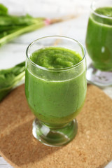 Healthy green smoothie with spinach on wooden table, closeup