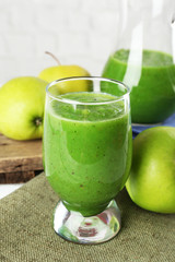 Healthy green smoothie with apples on sackcloth, closeup