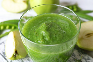 Healthy green smoothie with peas and apples on wooden table, closeup