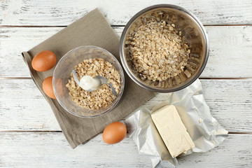 Ingredients for oatmeal cookies on wooden table, top view