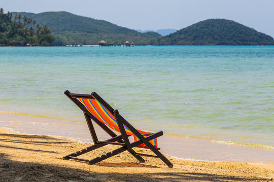 sun beach chairs on shore near sea.