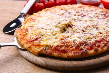 Cheese pizza on wooden cutting board, closeup