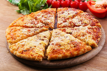 Cheese pizza on wooden cutting board, closeup