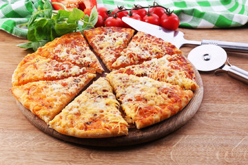 Cheese pizza on wooden cutting board, closeup