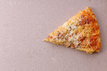 Piece of pizza on cardboard background