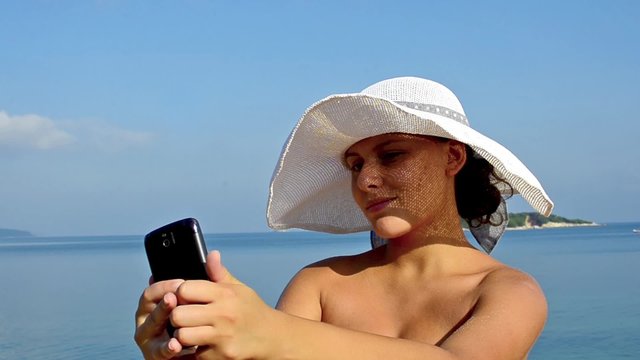 TAKING SELFIE. beautiful model taking selfie pictures with Smartphone at ocean beach