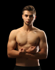 Fototapeta premium Muscle young man on dark background