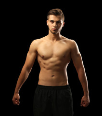 Fototapeta premium Muscle young man on dark background