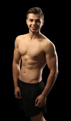 Fototapeta premium Muscle young man on dark background