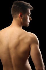 Fototapeta premium Muscle young man on dark background