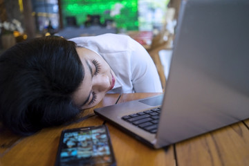 Tired businesswoman sleeping in the cafe