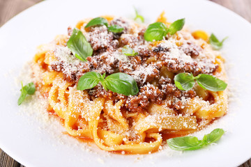Pasta Bolognese with parmesan and basil on plate close up