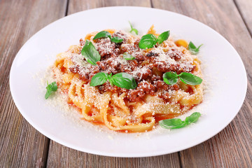 Pasta Bolognese with parmesan and basil on table close up