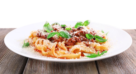 Pasta Bolognese with parmesan and basil on table isolated on white