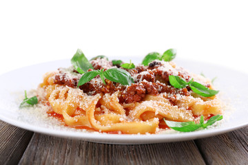 Pasta Bolognese with parmesan and basil on light background