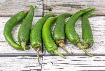 Chili peppers over wooden background