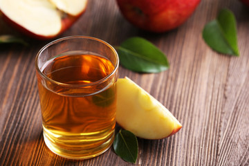 Glass of apple juice and fruits on table close up