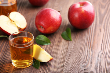 Naklejka na ściany i meble Glasses of apple juice and fruits on table close up