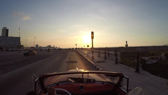 Driving classic convertible car wIth sunset in Havana, Cuba