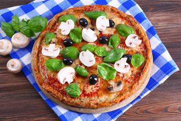 Tasty pizza with vegetables and basil on table close up
