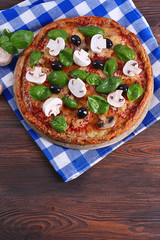 Tasty pizza with vegetables and basil on table close up